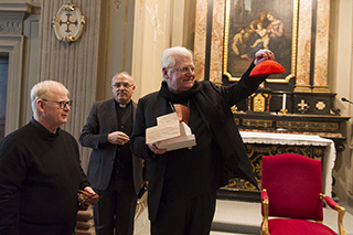 Il Cardinale Angelo Scola mostra lo zucchetto ricevuto in dono