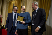  Cesare Giuzzi, Gruppo cronisti lombardi, e Paolo Perucchini, presidente Associazione lombarda dei giornalisti consegnano il premio speciale per la fotografia alla memoria di Giulio Giuzzi al fotografo Luca Matarazzo” height=