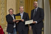  Michele Crosti, Gruppo cronisti lombardi, e il presidente dell'Associazione lombarda dei giornalisti Paolo Perucchini consegnano il terzo premio a Massimiliano Mingoia del Giorno” height=